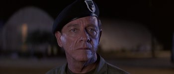 Movie still from “Rambo: First Blood Part II” (1985), directed by George P. Cosmatos – A man in a military uniform with a patch on his face; Close Up shot, Low angle