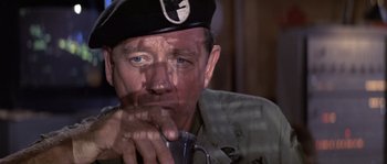 Movie still from “Rambo: First Blood Part II” (1985), directed by George P. Cosmatos – An older man wearing a hat and a uniform; Close Up shot, Over the shoulder angle