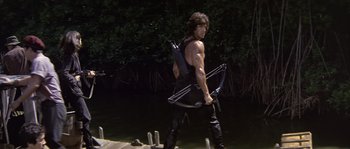 Movie still from “Rambo: First Blood Part II” (1985), directed by George P. Cosmatos – A man holding a bow and arrow; Wide shot, Low angle