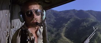 Movie still from “Rambo: First Blood Part II” (1985), directed by George P. Cosmatos – A man in a helicopter flying over a valley; Close Up shot, Low angle