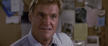 Movie still from “Rambo: First Blood Part II” (1985), directed by George P. Cosmatos – A person wearing a shirt and tie; Close Up shot, Low angle