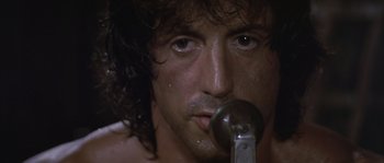 Movie still from “Rambo: First Blood Part II” (1985), directed by George P. Cosmatos – A person with a microphone; Extreme Close Up shot, Low angle
