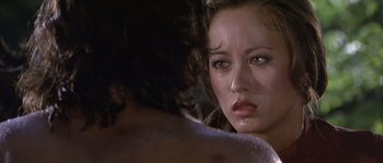 Movie still from “Rambo: First Blood Part II” (1985), directed by George P. Cosmatos – A woman's face as she stares at a man; Close Up shot, Over the shoulder angle