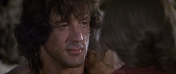 Movie still from “Rambo: First Blood Part II” (1985), directed by George P. Cosmatos – A man's face with water on his face; Close Up shot, Over the shoulder angle