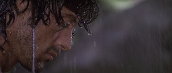 Movie still from “Rambo: First Blood Part II” (1985), directed by George P. Cosmatos – A man's face in the pouring rain; Close Up shot, Low angle