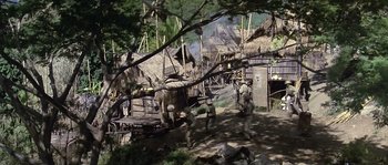 Movie still from “Rambo: First Blood Part II” (1985), directed by George P. Cosmatos – A group of people walking on a dirt path; Extreme Wide shot, High angle