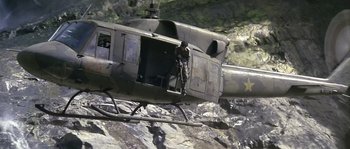 Movie still from “Rambo: First Blood Part II” (1985), directed by George P. Cosmatos – A man standing on the back of a helicopter; Wide shot, High angle