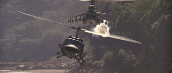 Movie still from “Rambo: First Blood Part II” (1985), directed by George P. Cosmatos – A helicopter spraying water on another helicopter flying in the air; Extreme Wide shot, Low angle