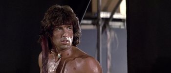 Movie still from “Rambo: First Blood Part II” (1985), directed by George P. Cosmatos – A person with a body of water in the background; Close Up shot, Low angle
