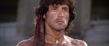Movie still from “Rambo: First Blood Part II” (1985), directed by George P. Cosmatos – A person wearing a necklace; Close Up shot, Low angle