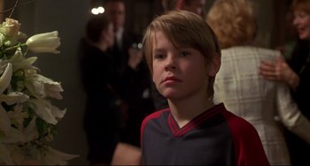 Movie still from “Ransom” (1996), directed by Ron Howard – A young boy in a red and black shirt; Close Up shot, Over the shoulder angle