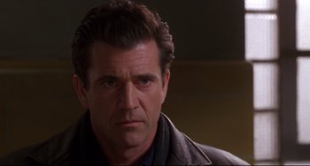 Movie still from “Ransom” (1996), directed by Ron Howard – A person wearing a suit and tie; Close Up shot, Over the shoulder angle