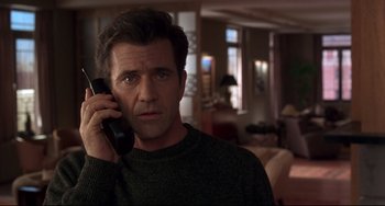 Movie still from “Ransom” (1996), directed by Ron Howard – A man holding a cell phone up to his ear; Close Up shot, Low angle
