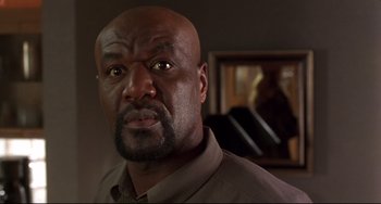 Movie still from “Ransom” (1996), directed by Ron Howard – A man with a bald head stares at the camera; Close Up shot, Low angle