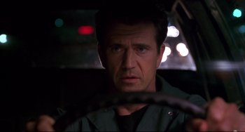 Movie still from “Ransom” (1996), directed by Ron Howard – A person driving a car at night; Close Up shot, Low angle