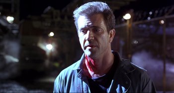 Movie still from “Ransom” (1996), directed by Ron Howard – A man with a bandana around his neck; Close Up shot, Over the shoulder angle