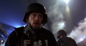 Movie still from “Ransom” (1996), directed by Ron Howard – A man wearing a helmet and a fbi uniform; Close Up shot, Low angle