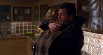 Movie still from “Ransom” (1996), directed by Ron Howard – A man and a woman hugging in a kitchen; Medium shot, Over the shoulder angle
