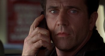 Movie still from “Ransom” (1996), directed by Ron Howard – A person talking on a cell phone; Close Up shot, Low angle