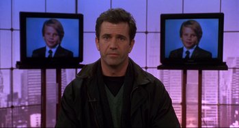 Movie still from “Ransom” (1996), directed by Ron Howard – A man in front of a television screen; Close Up shot, Over the shoulder angle