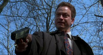 Movie still from “Ransom” (1996), directed by Ron Howard – A man in a suit and tie holding a gun; Close Up shot, Low angle