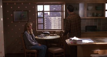 Movie still from “Ransom” (1996), directed by Ron Howard – A man and a woman sitting in front of a large window; Wide shot, Over the shoulder angle