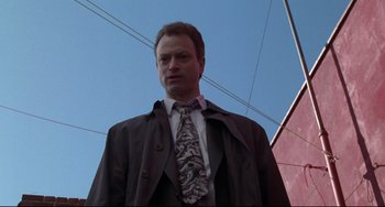 Movie still from “Ransom” (1996), directed by Ron Howard – A man in a suit and tie standing in front of a building; Close Up shot, Low angle