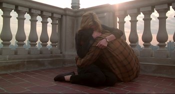 Movie still from “Ransom” (1996), directed by Ron Howard – A woman sitting on the ground hugging another woman; Medium shot, High angle