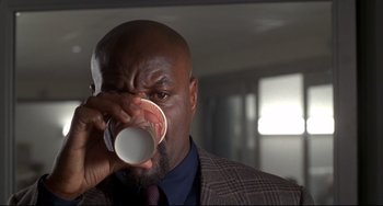 Movie still from “Ransom” (1996), directed by Ron Howard – A person drinking from a paper cup; Close Up shot, Low angle
