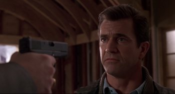 Movie still from “Ransom” (1996), directed by Ron Howard – A person holding a gun; Close Up shot, Low angle