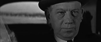 Movie still from “Rapture” (1965), directed by John Guillermin – An older man wearing a hat and a suit; Close Up shot, Low angle