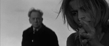 Movie still from “Rapture” (1965), directed by John Guillermin – A man and a woman standing next to each other; Close Up shot, Low angle