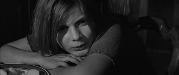 Movie still from “Rapture” (1965), directed by John Guillermin – A black - and - white photo of a woman leaning on a chair; Close Up shot, High angle
