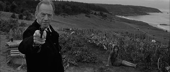 Movie still from “Rapture” (1965), directed by John Guillermin – A man and a woman sitting in a field; Medium shot, Over the shoulder angle