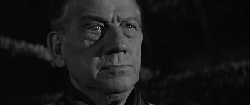 Movie still from “Rapture” (1965), directed by John Guillermin – An older man with a serious look on his face; Close Up shot, Low angle