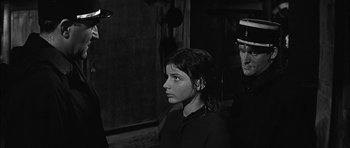 Movie still from “Rapture” (1965), directed by John Guillermin – A woman standing next to a man in a room; Close Up shot, Over the shoulder angle