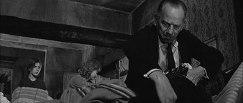 Movie still from “Rapture” (1965), directed by John Guillermin – An older man and a young boy in a room; Medium shot, Low angle