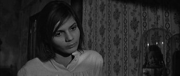 Movie still from “Rapture” (1965), directed by John Guillermin – A woman in a white shirt is in front of a curtain; Close Up shot, Over the shoulder angle