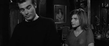 Movie still from “Rapture” (1965), directed by John Guillermin – A man and a woman standing next to each other in a room; Close Up shot, Over the shoulder angle