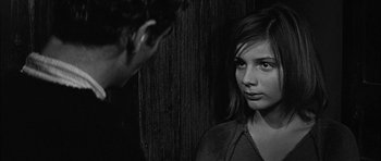 Movie still from “Rapture” (1965), directed by John Guillermin – A woman standing next to a man in front of a wooden wall; Close Up shot, Over the shoulder angle