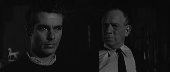 Movie still from “Rapture” (1965), directed by John Guillermin – A man and an older man standing next to each other in the dark; Close Up shot, Low angle