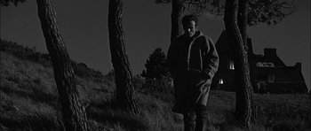 Movie still from “Rapture” (1965), directed by John Guillermin – A man standing next to a tree in a field; Wide shot, Low angle