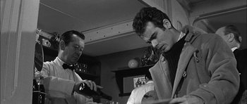 Movie still from “Rapture” (1965), directed by John Guillermin – Two men are looking at papers in a living room; Close Up shot, Low angle