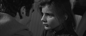 Movie still from “Rapture” (1965), directed by John Guillermin – A young woman looking into the distance while a man looks at her; Close Up shot, Over the shoulder angle
