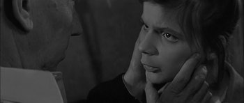 Movie still from “Rapture” (1965), directed by John Guillermin – A black - and - white photo of a man with his hand on his chin; Close Up shot, Over the shoulder angle
