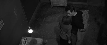 Movie still from “Rapture” (1965), directed by John Guillermin – A man and a woman are kissing in a room; Medium shot, High angle