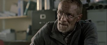 Movie still from “Rare Exports” (2010), directed by Jalmari Helander – An older man with a beard and glasses; Close Up shot, Over the shoulder angle