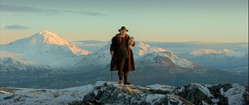 Movie still from “Rare Exports” (2010), directed by Jalmari Helander – A man standing on top of a snow covered mountain; Wide shot, Low angle
