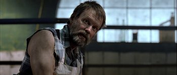 Movie still from “Rare Exports” (2010), directed by Jalmari Helander – A man with a beard wearing an apron; Close Up shot, Low angle