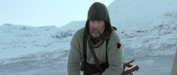 Movie still from “Rare Exports” (2010), directed by Jalmari Helander – A man with a beard wearing a sweater and a hat; Medium shot, Low angle